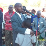 Rev.Peter Ndamba praying to one of the Orphans.